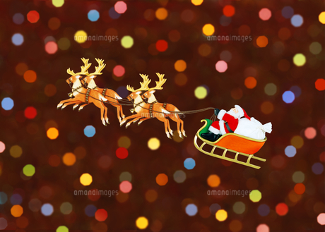 ソリに乗ったサンタクロースとイルミネーションの写真素材