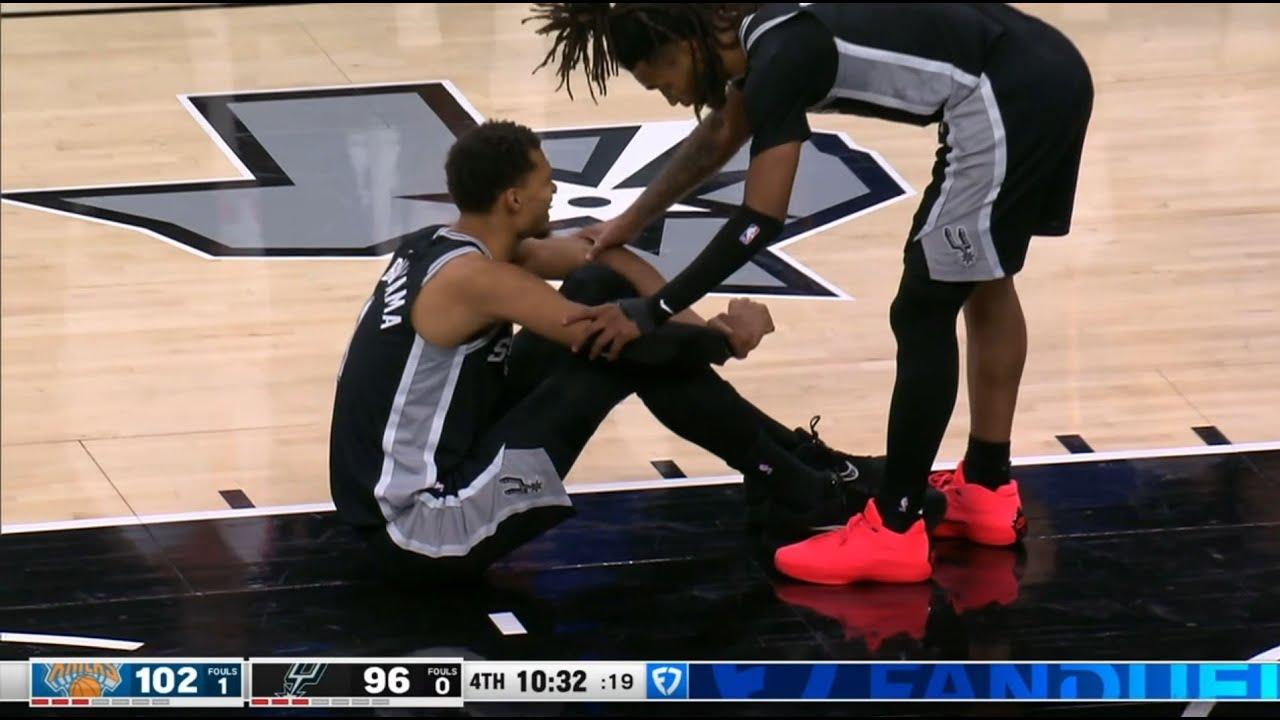 Victor Wembanyama goes down holding his knee, limps to the locker