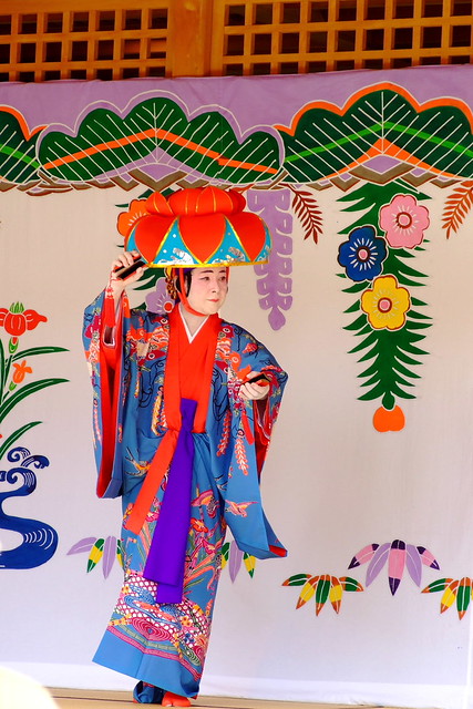 琉球舞踊| 南国の美を象徴する花笠をかぶる華やかな衣裳を着る踊り手が