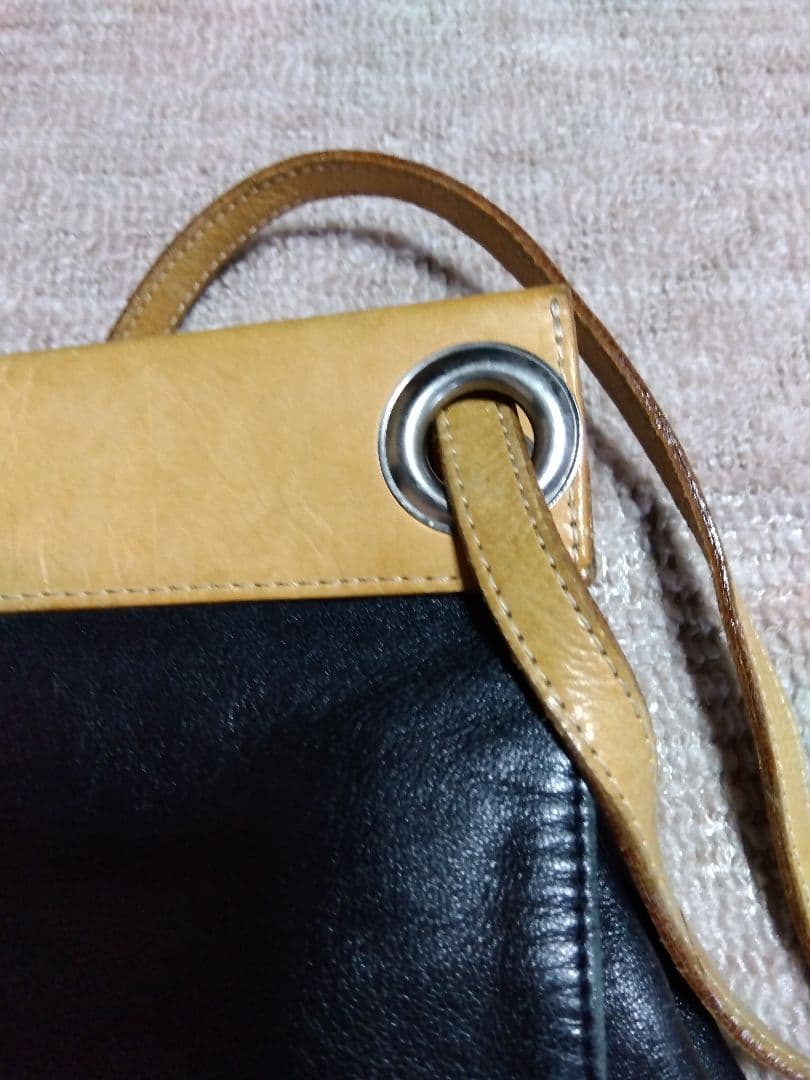 レザー製リュック 黒と黄 Mのロゴ