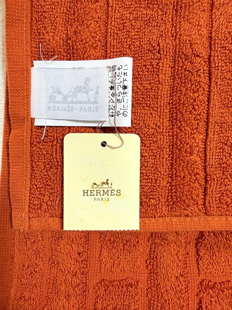 エルメス（HERMES）のHロゴ入りデザインのオレンジ色のコットン